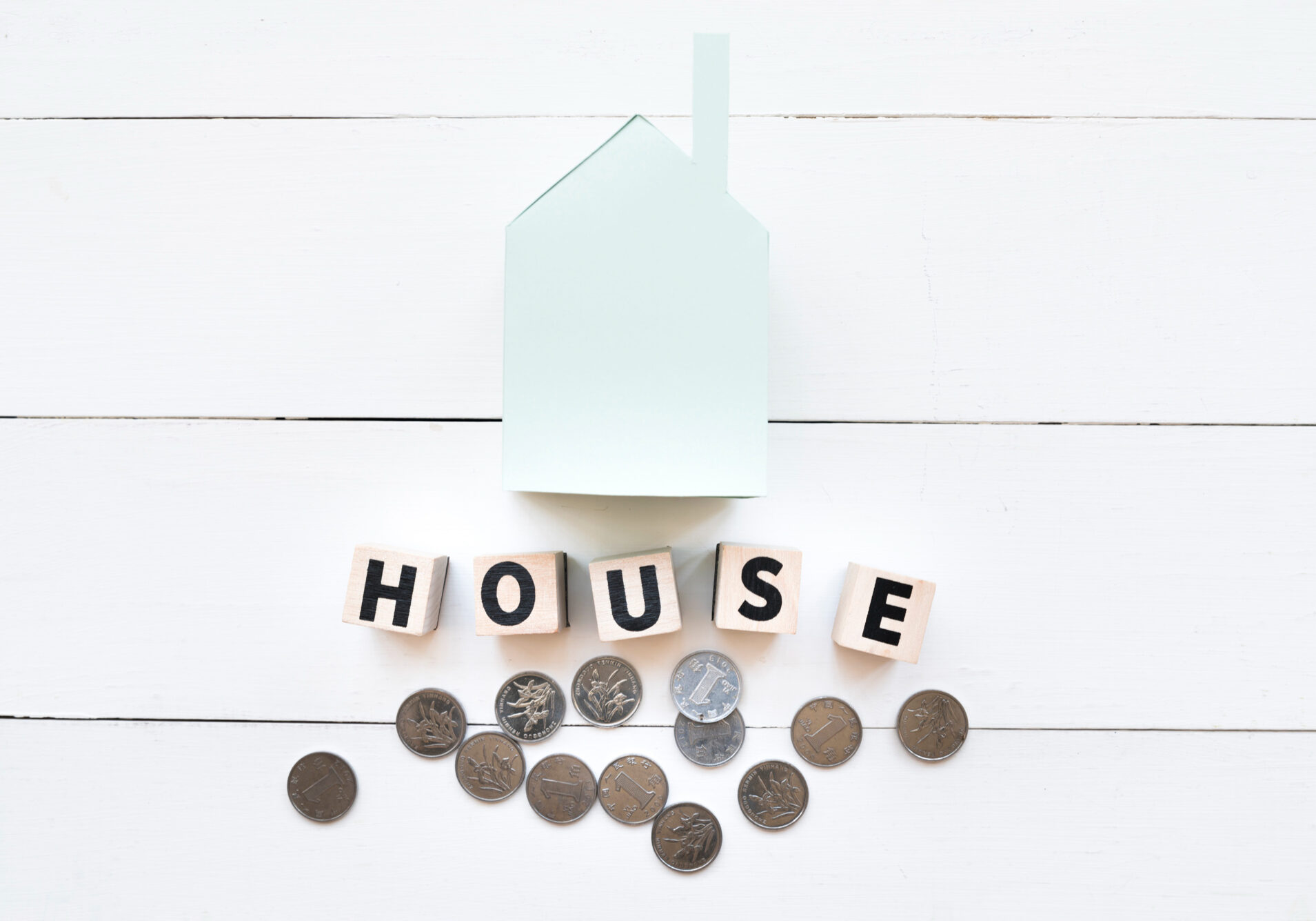 blue-paper-house-model-with-wooden-blocks-coins-white-wooden-backdrop blue-paper-house-model-with-wooden-blocks-coins-white-wooden-backdrop